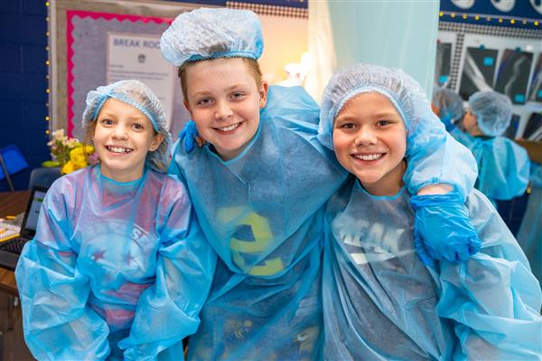 three students in scrubs smiling